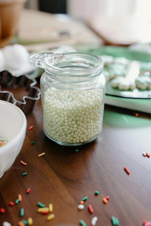 a table topped with a bowl of cereal next to a bowl of sprinkles, jars, real pearls, thumbnail, white pearlescent