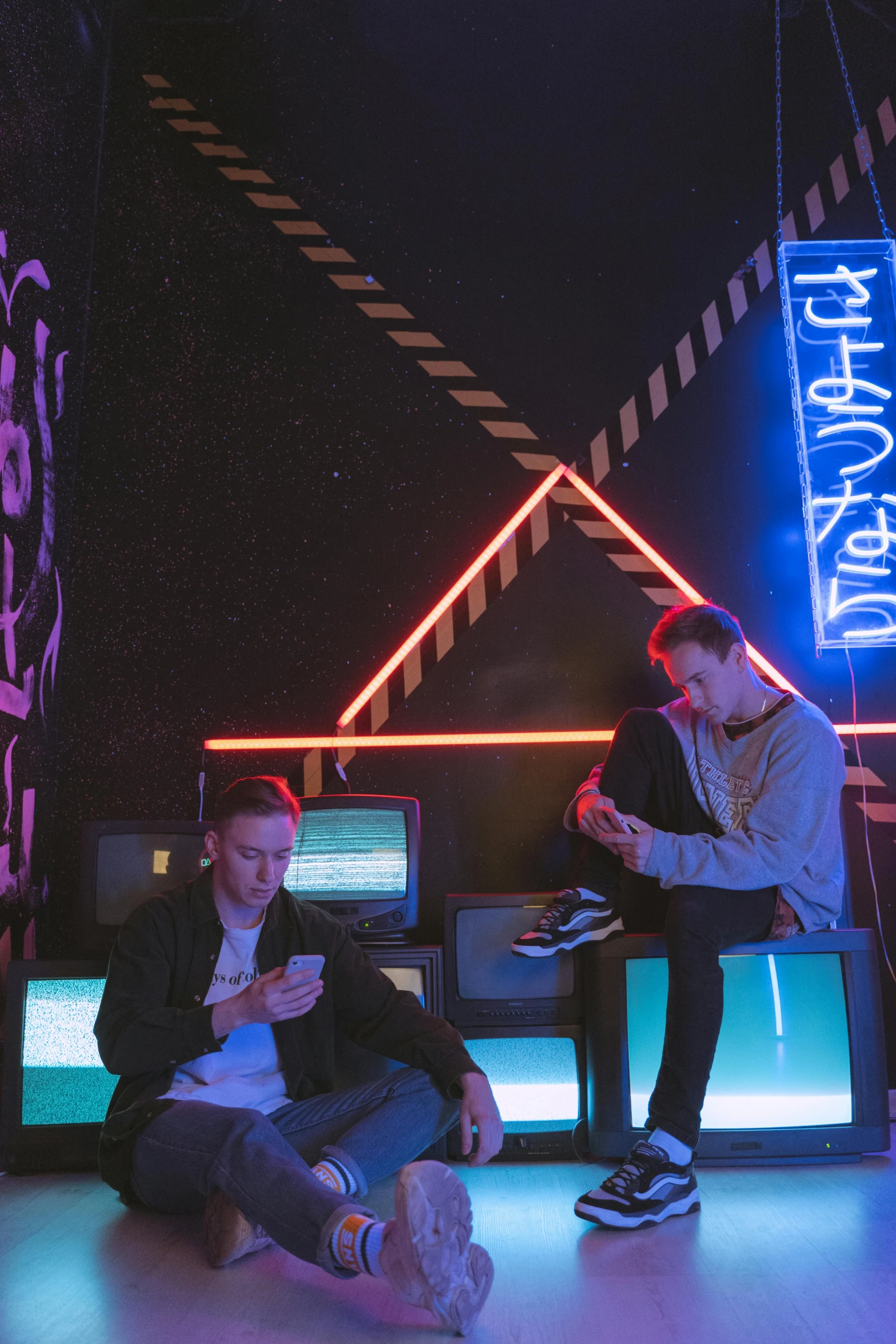 a group of people sitting next to each other on a stage, an album cover, pexels, graffiti, cyber neon lighting, two buddies sitting in a room, computer aesthetic, merchants