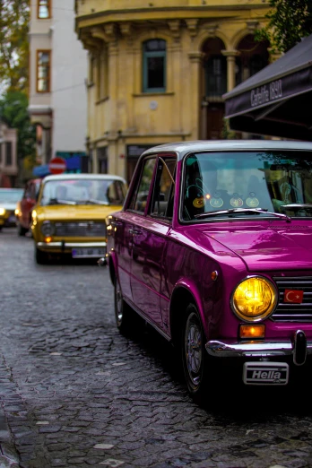 a purple car is parked on a cobblestone street, by Sven Erixson, pexels contest winner, renaissance, fallout style istanbul, pink and yellow, vintage cars