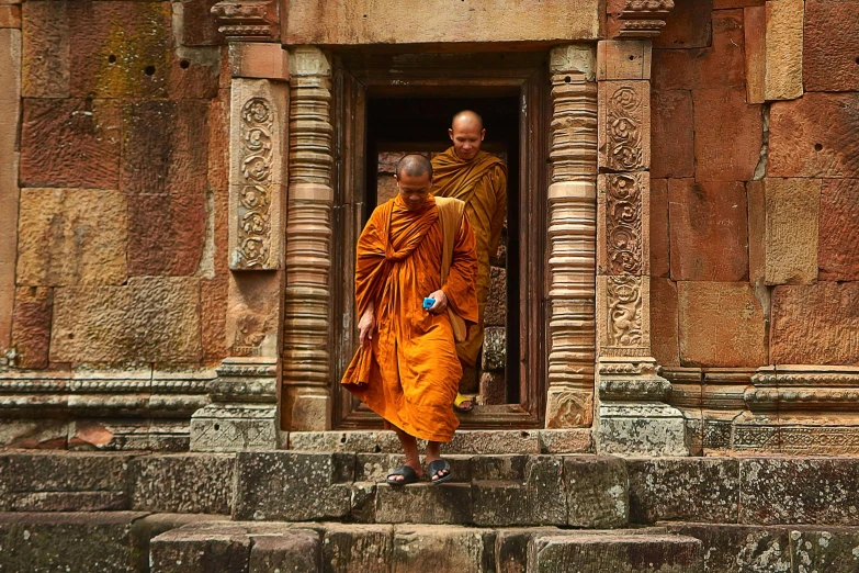 a couple of men that are standing in a doorway, inspired by Steve McCurry, pexels contest winner, renaissance, buddhist monk meditating, kailasa temple, walking down, brown