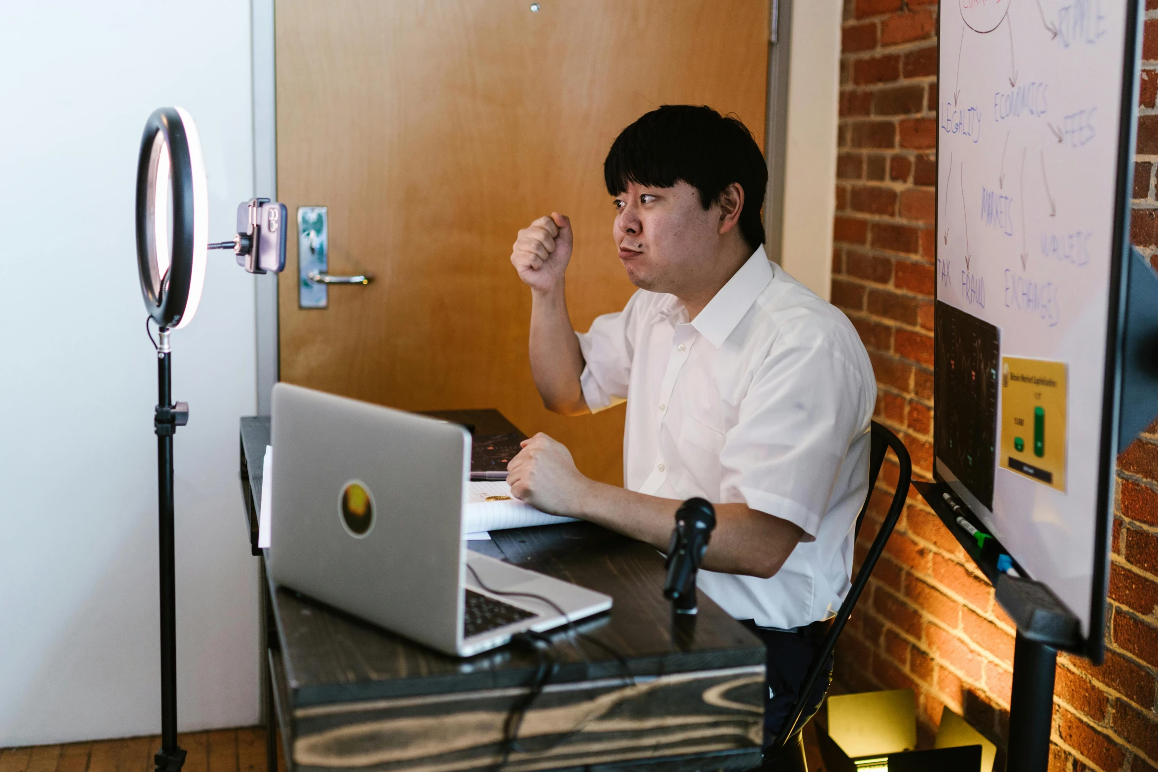 a man sitting in front of a laptop computer, by Jang Seung-eop, unsplash, holding microphone, lawther sit at table playing dnd, hunched shoulders, giving an interview