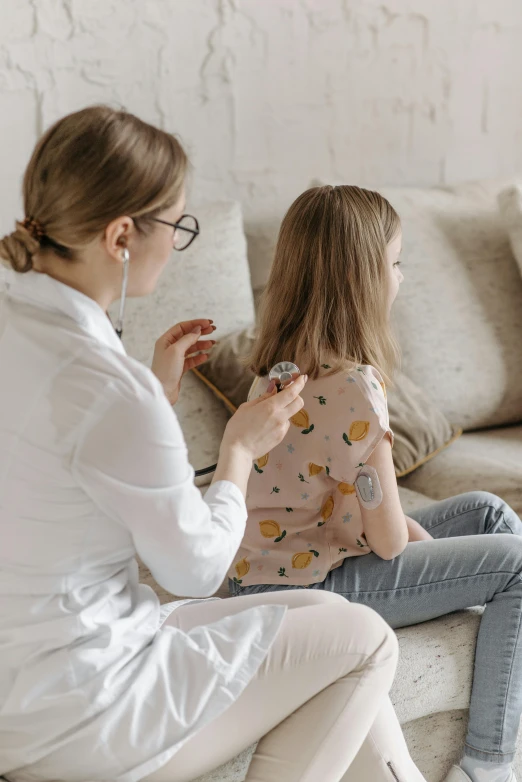 a woman and a little girl sitting on a couch, pexels, with a stethoscope, profile image, syringe, from back