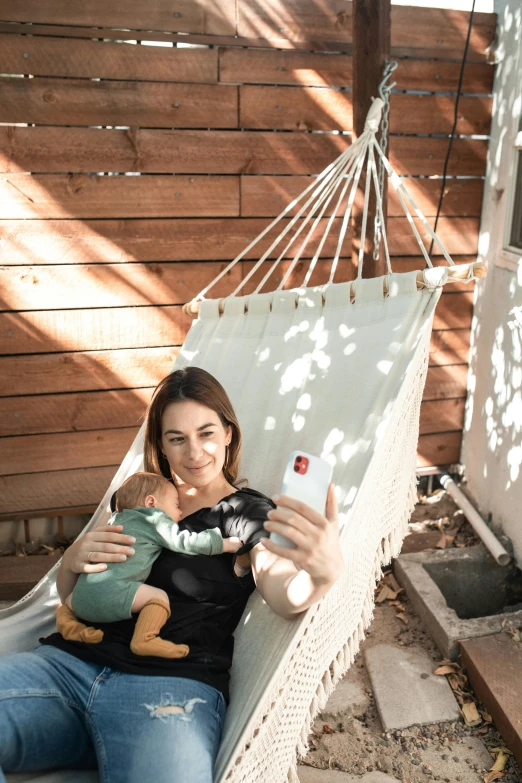 a woman sitting in a hammock holding a teddy bear, a polaroid photo, happening, babies in her lap, chilean, influencer, backyard