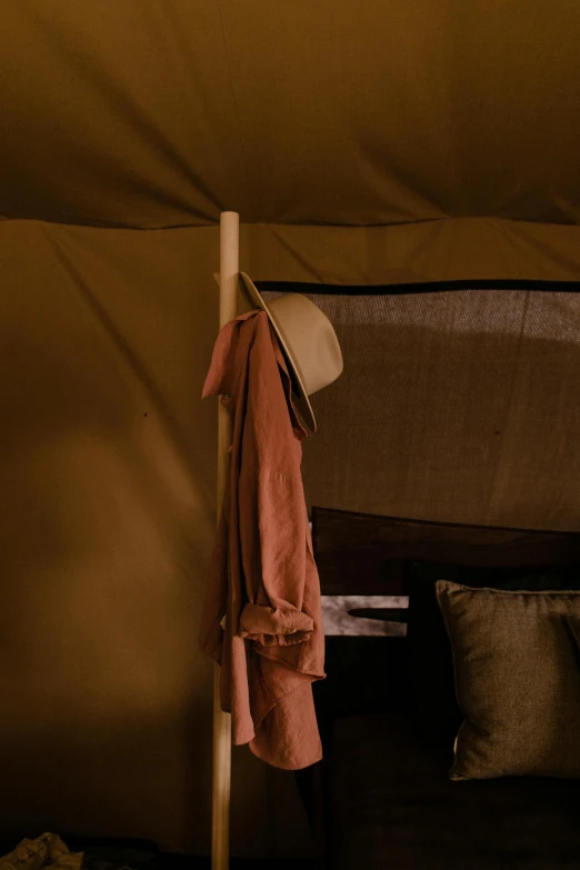 a bed sitting inside of a tent next to pillows, a portrait, by Lee Loughridge, unsplash, ferred - themed robes and hat, safari, texture detail, bedhead