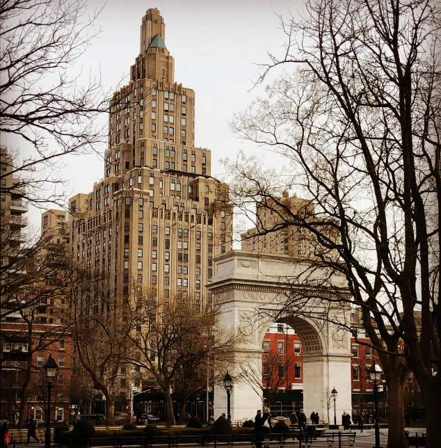 a very tall building in the middle of a city, a photo, pexels contest winner, art nouveau, archway, central park, neo-gothic, slight overcast