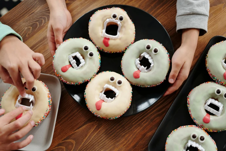 a close up of a plate of doughnuts with faces on them, trending on pexels, mingei, scary vampire, 6 pack, 4 0 0 mm, eating cakes