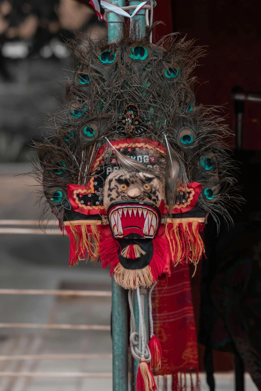 a close up of a mask on a pole, inspired by Li Kan, pexels contest winner, sumatraism, centered headdress, square, bali, on set