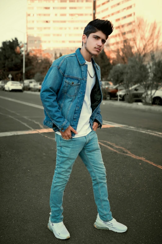 a man standing in the middle of a parking lot, an album cover, by Robbie Trevino, pexels contest winner, wearing a jeans jackets, profile image, with teal clothes, street wears
