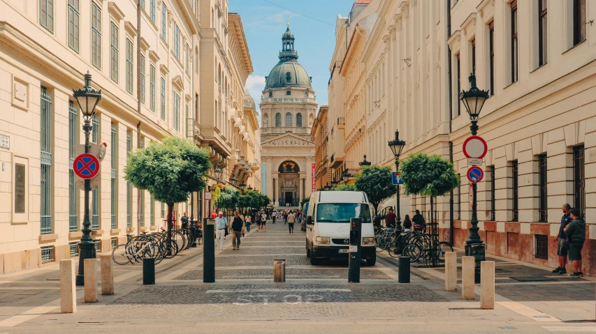 a white van driving down a street next to tall buildings, pexels contest winner, art nouveau, budapest, busy streets filled with people, thumbnail, square