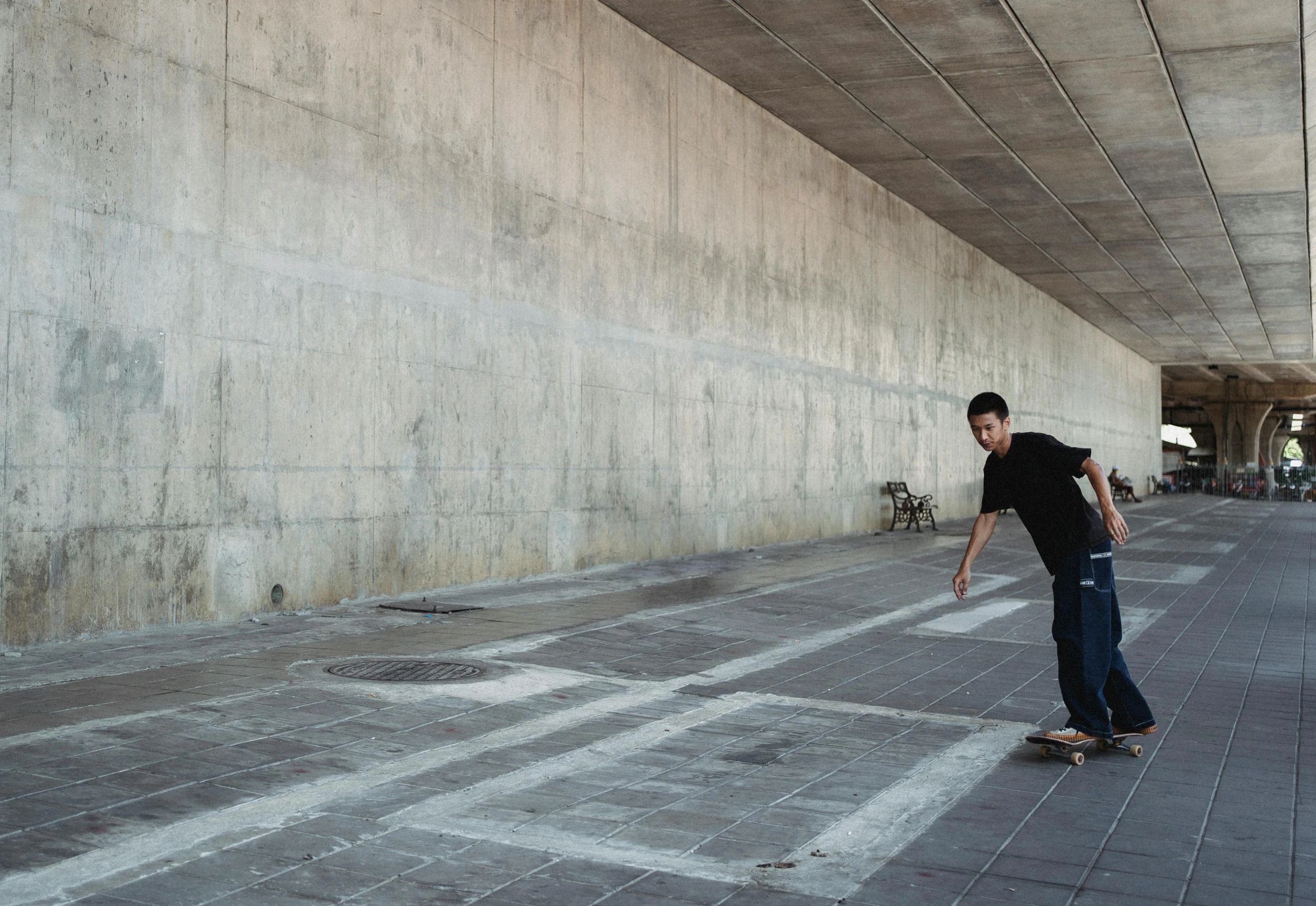 a man riding a skateboard down a sidewalk, by Pablo Rey, overpass, carles dalmau, waiting behind a wall, gray concrete