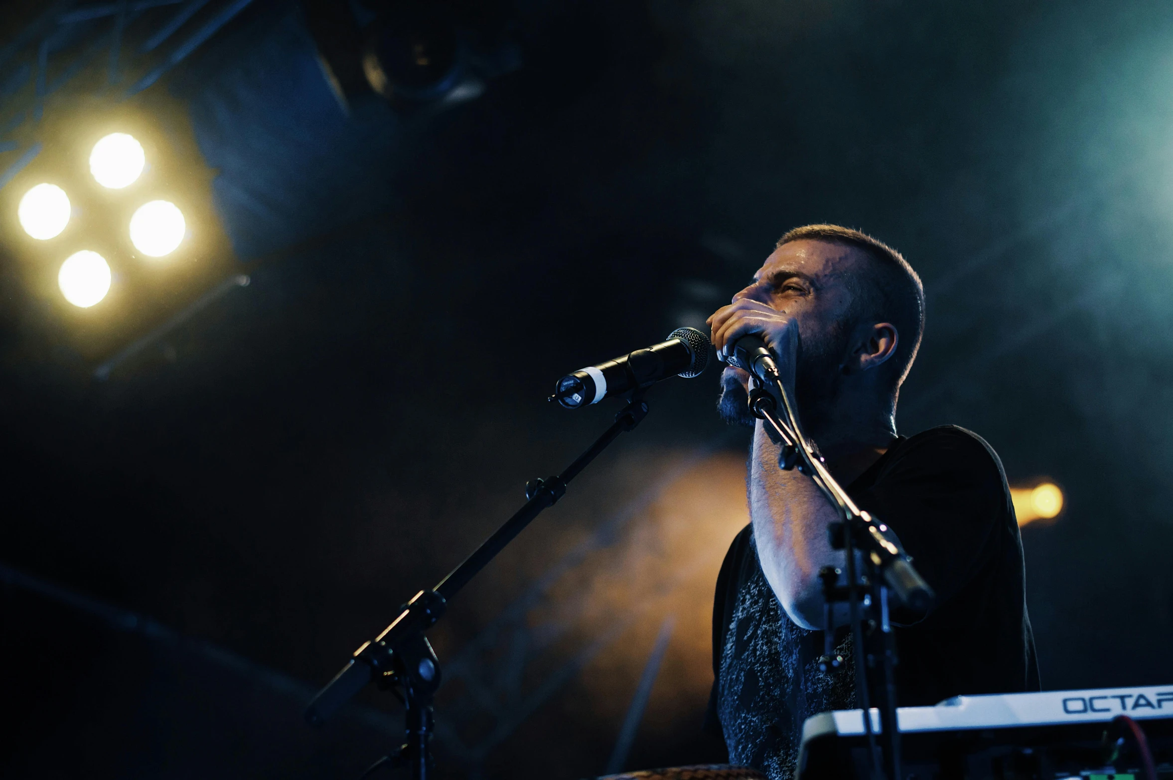 a man standing next to a keyboard on top of a stage, pexels contest winner, hurufiyya, buzz cut, acoustic information, portrait image