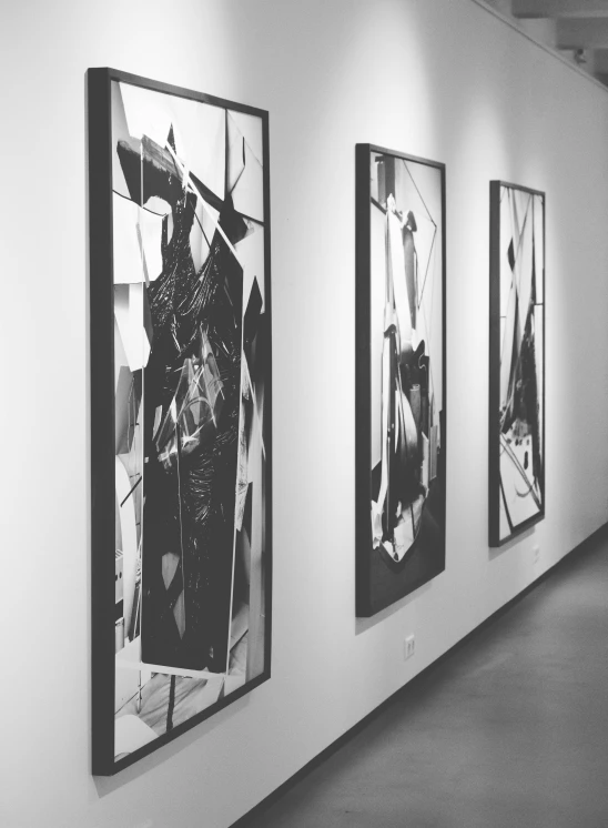 a black and white photo of paintings on a wall, a black and white photo, pexels, abstract expressionism, gallery lighting, vertical, museum display, asymmetrical artwork