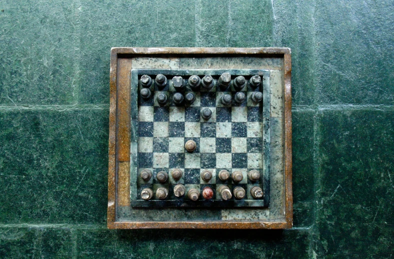 a close up of a chess board on a wall, an album cover, by Alison Geissler, unsplash, concrete art, of a old 16th century, verdigris, ignant, 1 5 6 6