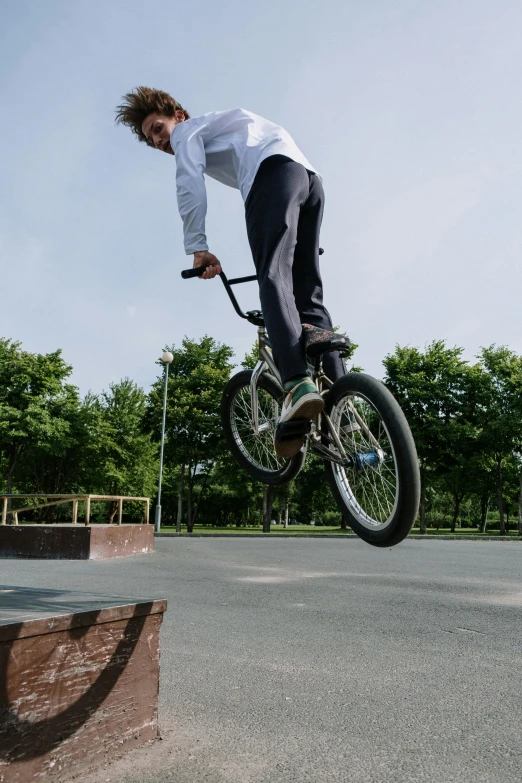 a man flying through the air while riding a bike, a picture, unsplash, realism, skatepark, low quality photo, hyperdetailed, brown