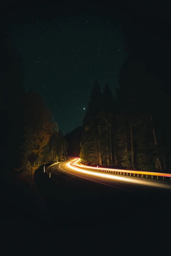 a car driving down a road at night, near forest, 2 5 6 x 2 5 6 pixels, unsplash photography, ansel ]