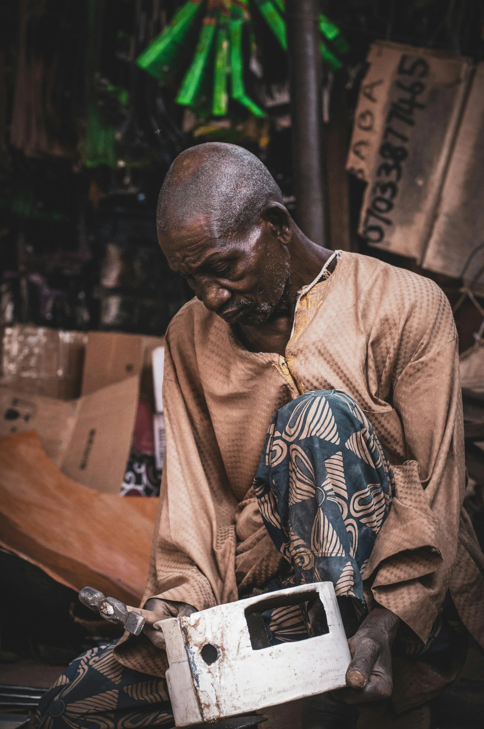 a man that is sitting down with a box, by Matija Jama, pexels contest winner, happening, male emaciated, adebanji alade, sitting on a store shelf, praying