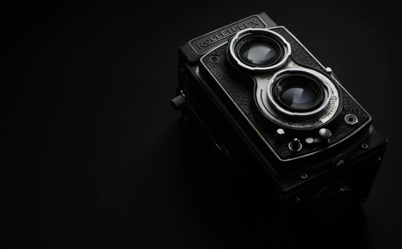 an old camera sitting on top of a table, a black and white photo, by Adam Marczyński, unsplash contest winner, photorealism, rolleiflex tlr, hq 4k phone wallpaper, black 3 d cuboid device, medium format. soft light