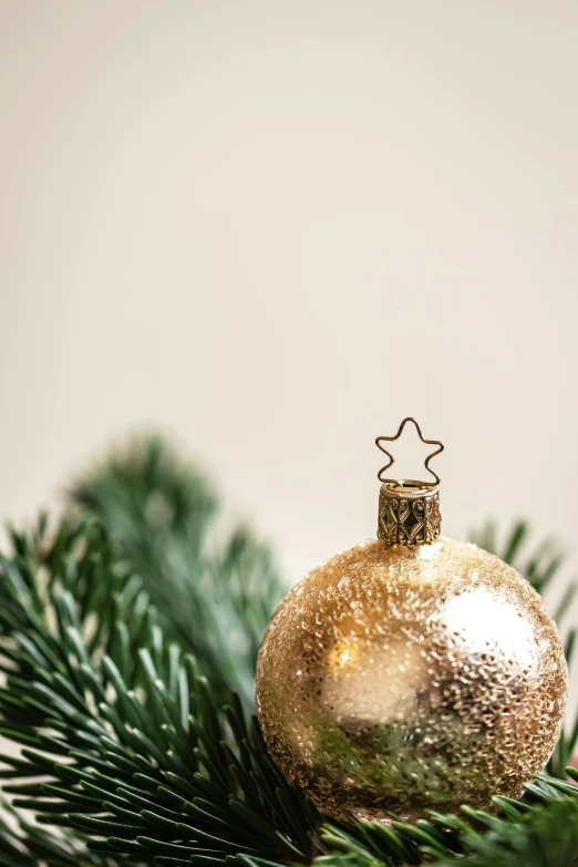 a close up of a christmas ornament on a tree, trending on unsplash, baroque, relaxed. gold background, multiple stories, high resolution product photo, 15081959 21121991 01012000 4k