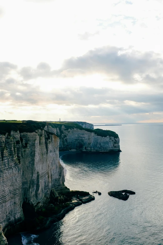 a large body of water next to a cliff, by Simon Marmion, pexels contest winner, romanticism, the normandy landings, limestone, conde nast traveler photo, farming