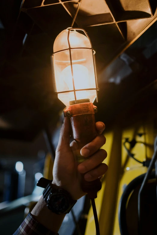 a person holding a light in their hand, pexels contest winner, renaissance, mechanic, yellow lighting from right, vintage vibe, worn