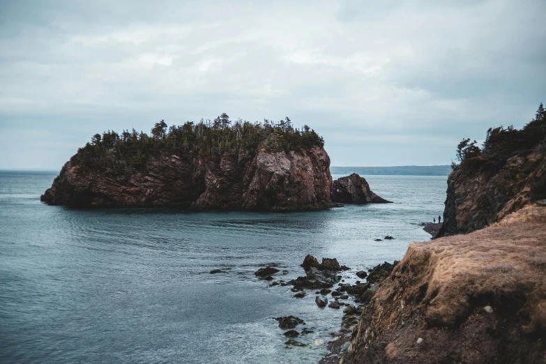 a small island in the middle of a body of water, pexels contest winner, coastal cliffs, “ iron bark, dan ouellette, slight overcast