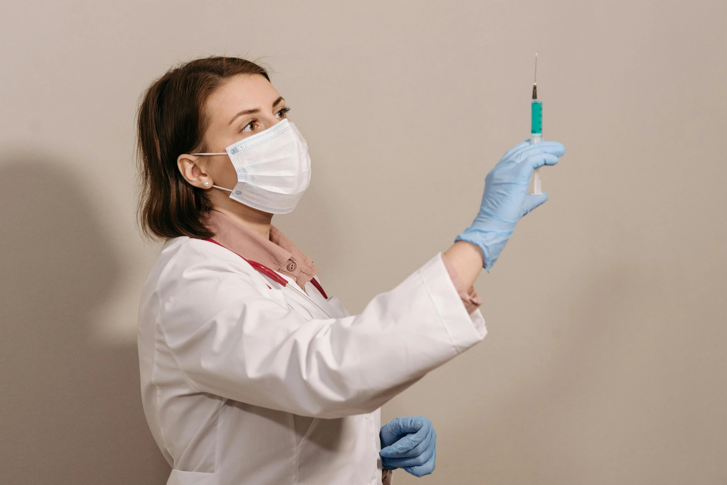 a woman in a lab coat holding a needle, pexels contest winner, iv pole, brown, background image, nurse costume