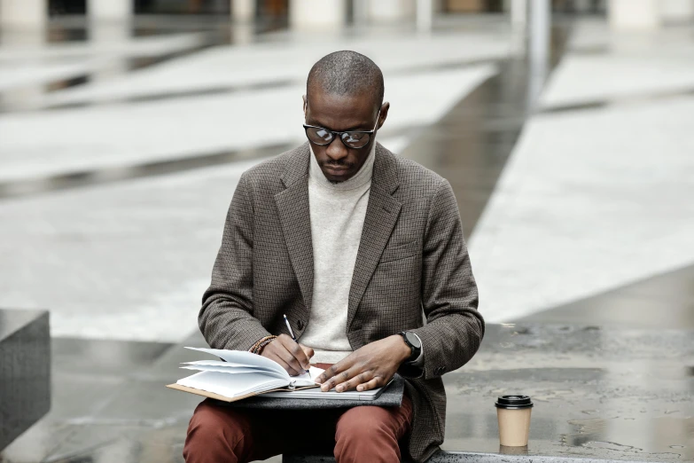 a man sitting on a bench reading a book, inspired by Barthélemy Menn, pexels contest winner, wearing wool suit, holding notebook, godwin akpan, black chalk