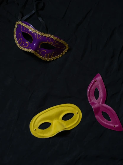 a couple of masks laying on top of a bed, by Adam Rex, close-up photograph, tabletop game props, 1990s photograph, multi colored