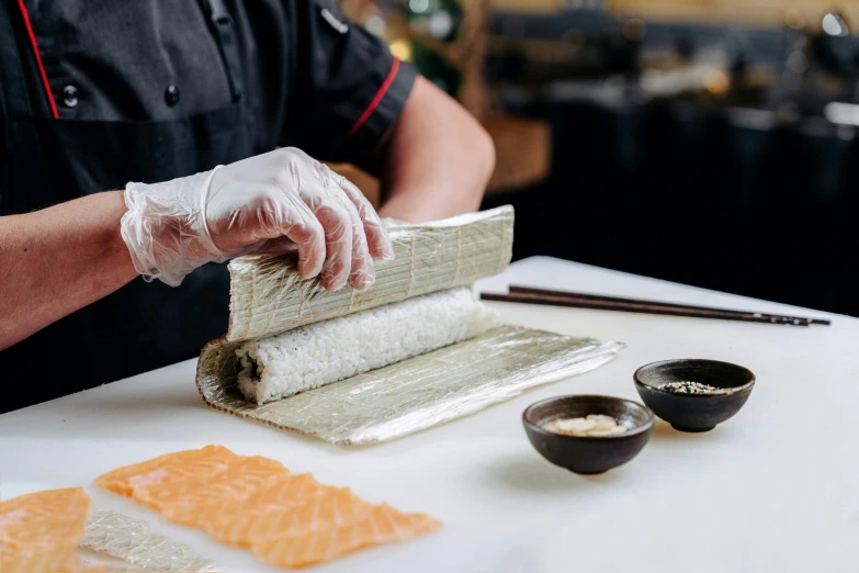 a close up of a person preparing food on a table, inspired by Maki Haku, unsplash, ukiyo-e, fish skin, foil, melbourne, creamy