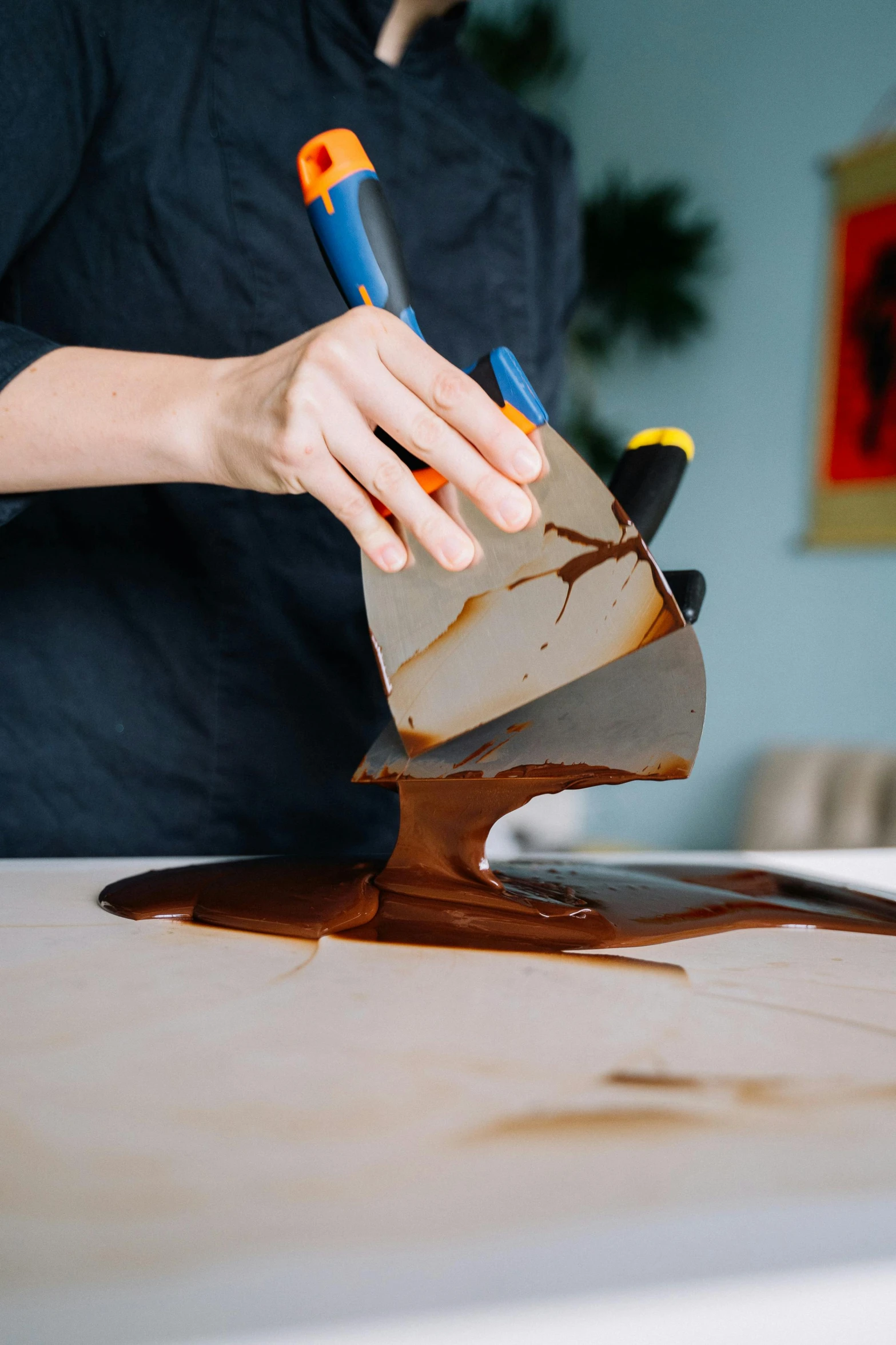 a woman cutting a piece of chocolate with a pair of scissors, by Julia Pishtar, process art, using a spade, on a table, screen melting, super smooth