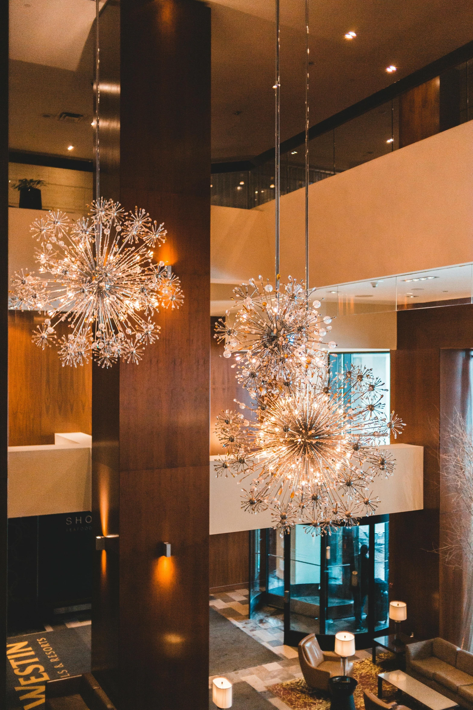 a living room filled with furniture and a chandelier, hanging tiffany chandeliers, dramatic view, starry, natural lighting