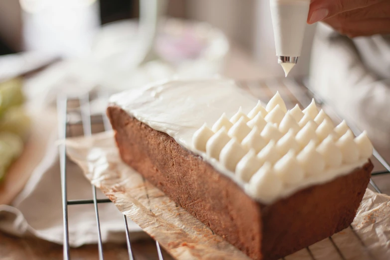 a close up of a cake on a cooling rack, trending on pexels, figuration libre, pouring techniques, white clay, on a wooden table, white tracing