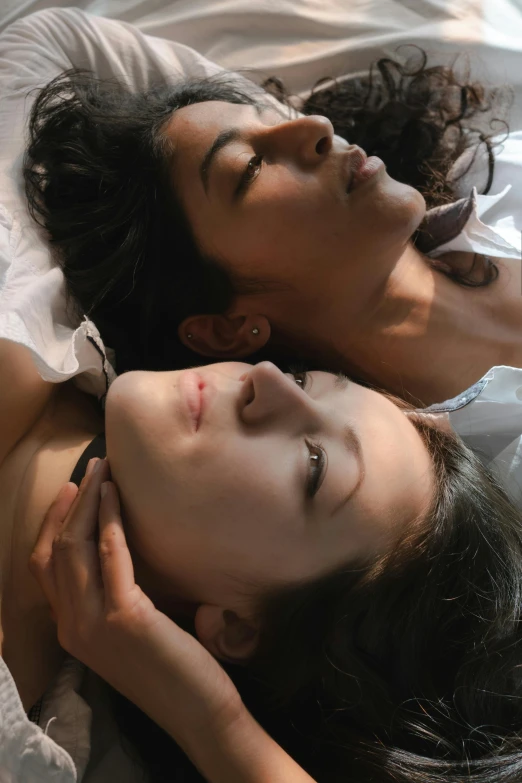 a couple of women laying on top of a bed, an album cover, inspired by Nan Goldin, renaissance, closeup faces, alessio albi and shin jeongho, profile image, scene from live action movie
