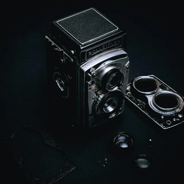 an old camera sitting on top of a table, on a black background, rolleiflex tlr, high-quality photo, unsplash photography