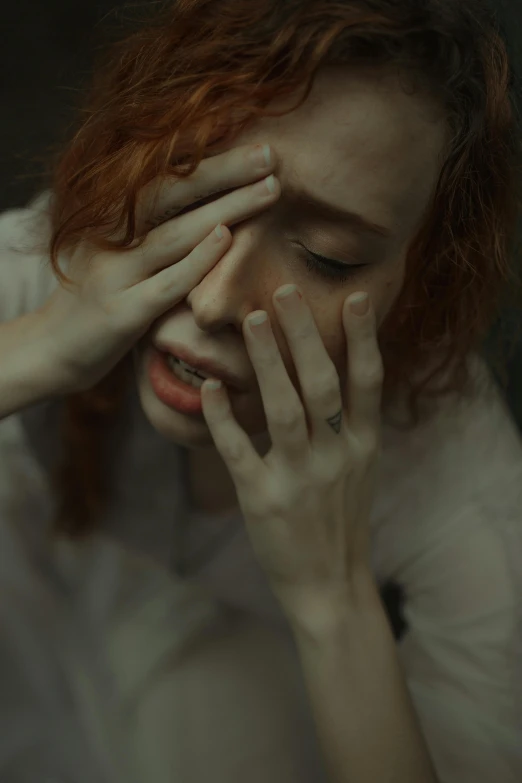 a woman with red hair covering her eyes, inspired by Elsa Bleda, trending on pexels, movie still of a tired, woman crying, lysergic, pale woman