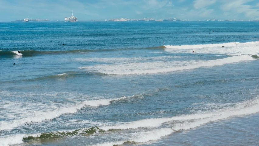 a man riding a wave on top of a surfboard, by Charlotte Harding, pexels contest winner, colombo sri lanka cityscape, seen from far away, panorama, santa monica beach