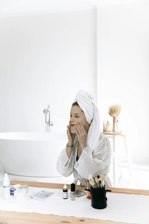 a woman sitting in front of a mirror with a towel on her head, pexels contest winner, renaissance, on a white table, bubbling skin, gif, designer product
