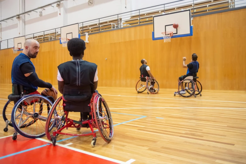 a group of men in wheelchairs playing a game of basketball, by David Burton-Richardson, eye level view, profile image, kousuke oono, panoramic shot