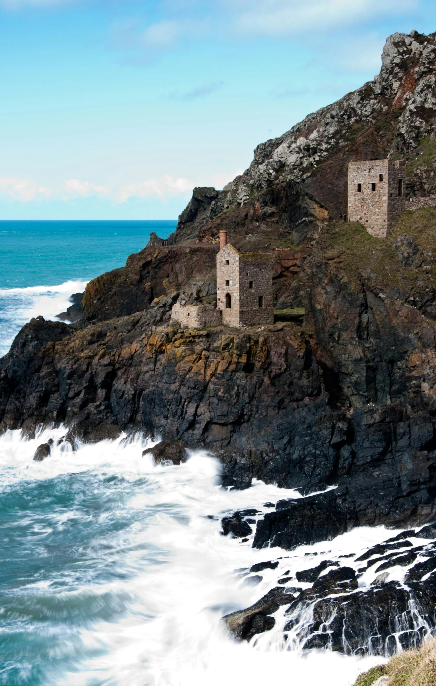 a lighthouse sitting on top of a cliff next to the ocean, medieval tumbledown houses, waterwheels, cornwall, slide show