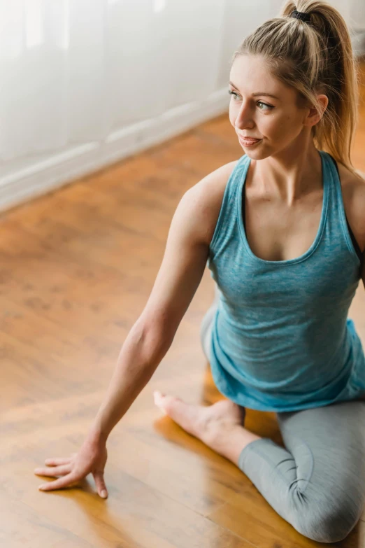 a woman sitting on the floor in a yoga pose, looking across the shoulder, well defined, square, lynn skordal