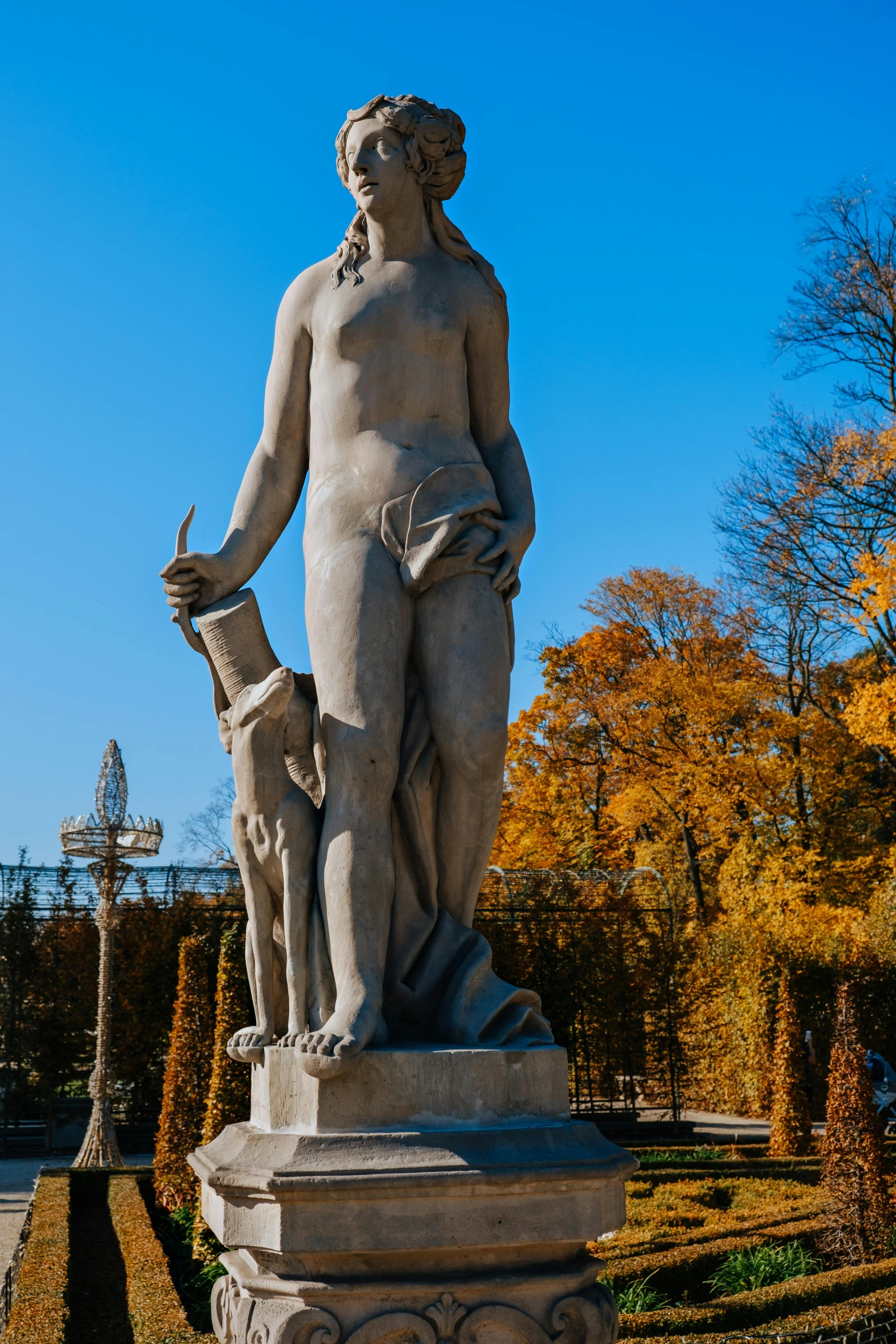 a statue of a woman and a dog in a park, by Harry Haenigsen, unsplash, neoclassicism, the goddess of autumn harvest, full front view, venus, capital of estonia