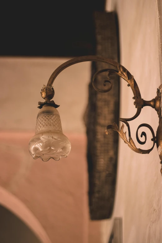 a close up of a light on a wall, unsplash, art nouveau, in a medieval tavern at night, graceful curves, transparent, sconces