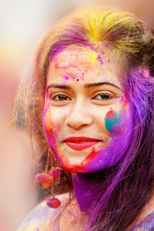 a woman with colorful paint on her face, a picture, trending on pexels, color field, young himalayan woman, purple and scarlet colours, joyful smirk, colorful crowd