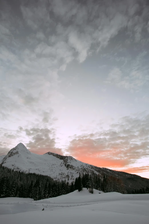 a man riding skis down a snow covered slope, a picture, unsplash contest winner, minimalism, sunset and big clouds behind her, banff national park, “ aerial view of a mountain, waking up