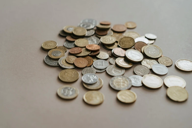 a pile of coins sitting on top of a table, from the distance, detailed product image, muted browns, diverse