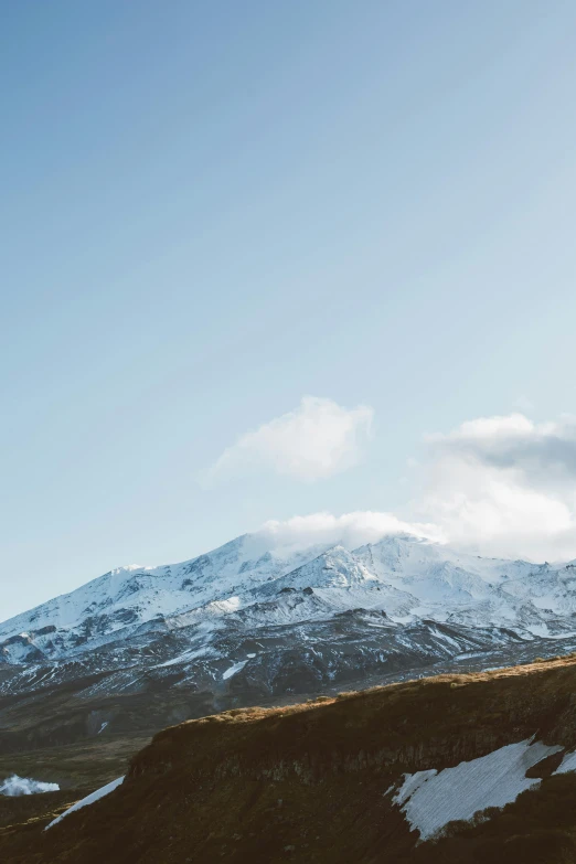 a man standing on top of a snow covered mountain, a matte painting, trending on unsplash, hurufiyya, mount doom, clear blue skies, manuka, slightly golden