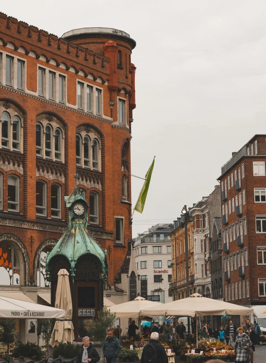 a group of people walking down a street next to tall buildings, a photo, pexels contest winner, art nouveau, swedish houses, gold and green, high details!, market square