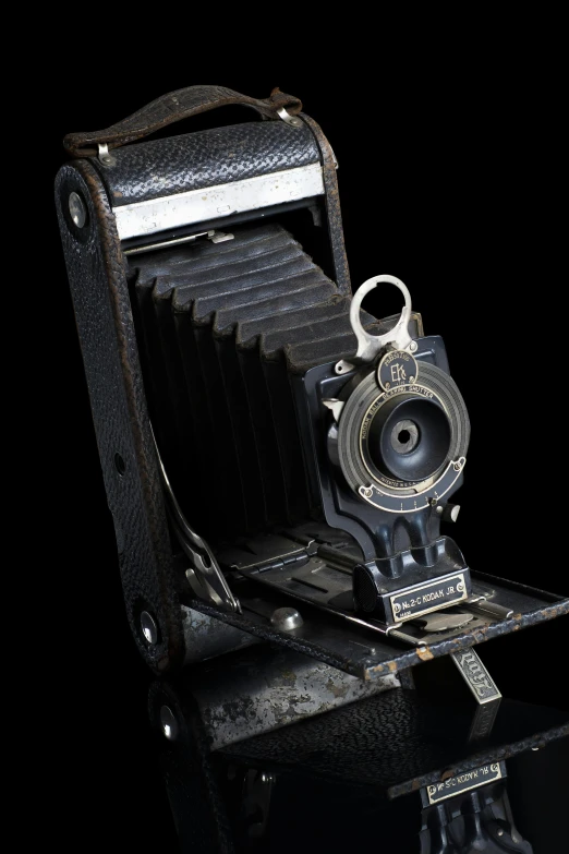 an old camera sitting on top of a table, on a black background, portrait n - 9, folded, f / 2 0