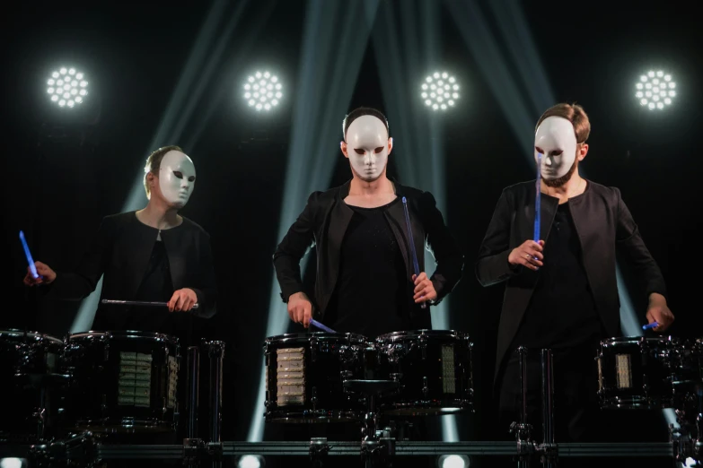 a group of men standing next to each other on a stage, a portrait, unsplash, antipodeans, chrome mask, drum pads, mirrored, 3 actors on stage