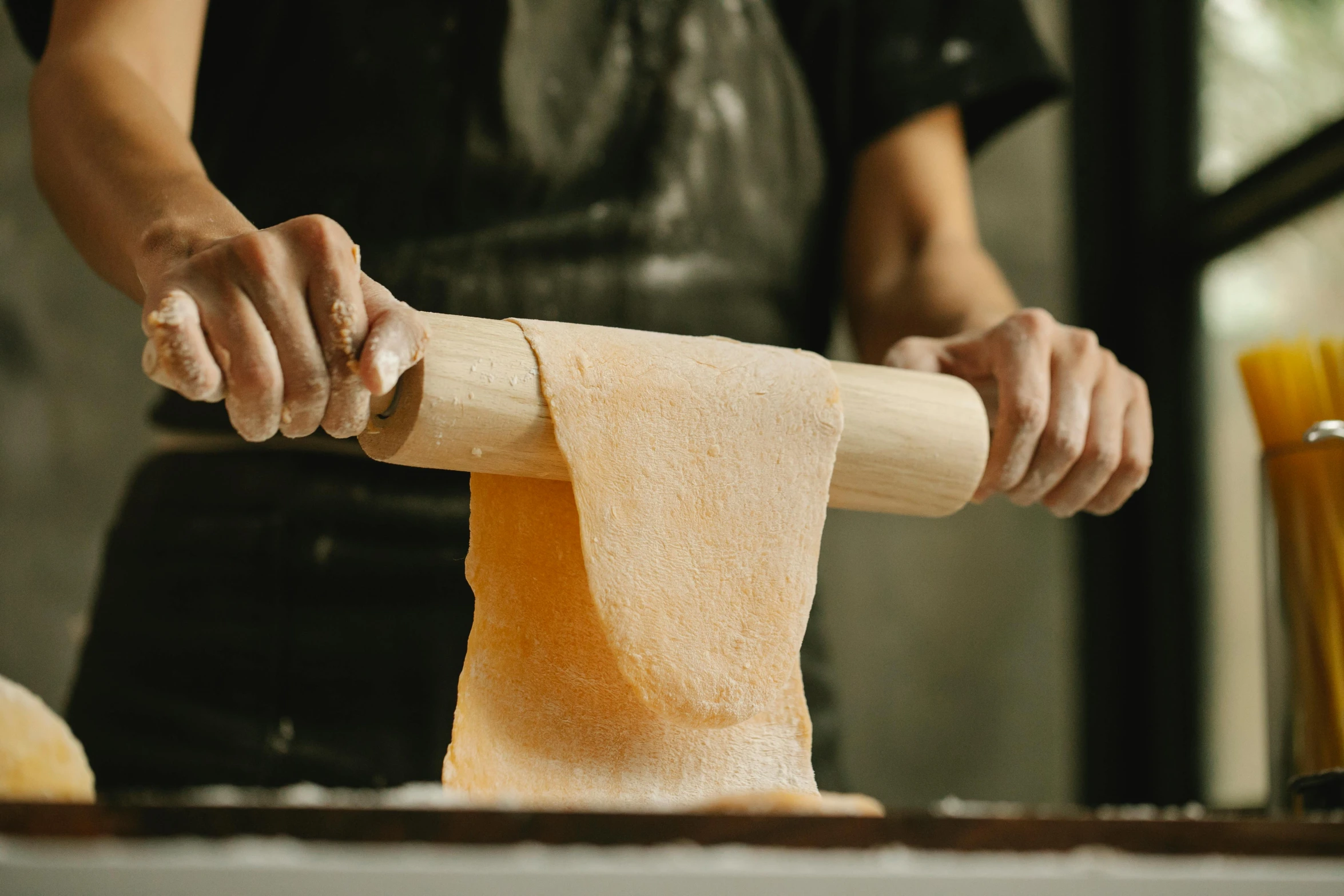 a person rolling dough with a rolling pin, by Lee Loughridge, trending on pexels, ramen, melbourne, long trunk holding a wand, cheesy